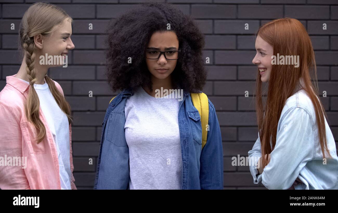 Mitschüler beleidigen afrikanische Schüler aussehen Lachen, emotionaler Mißbrauch Stockfoto