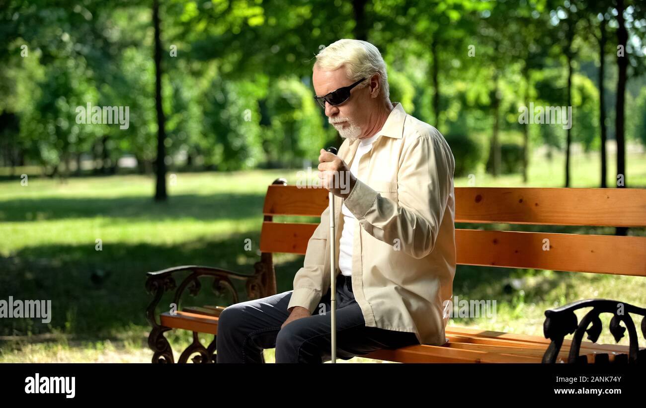 Blinde Menschen allein sitzt im Park gedrückt, die sozial benachteiligten Bevölkerung Stockfoto