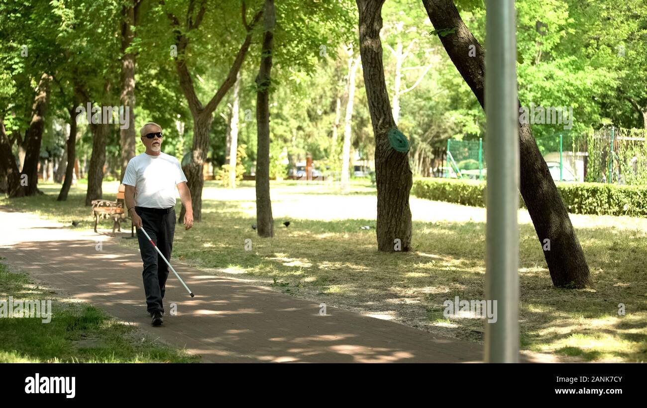 Blinde alte Mann Hindernisse erkennen mit weißen Stock, Wandern im Park unabhängige Stockfoto