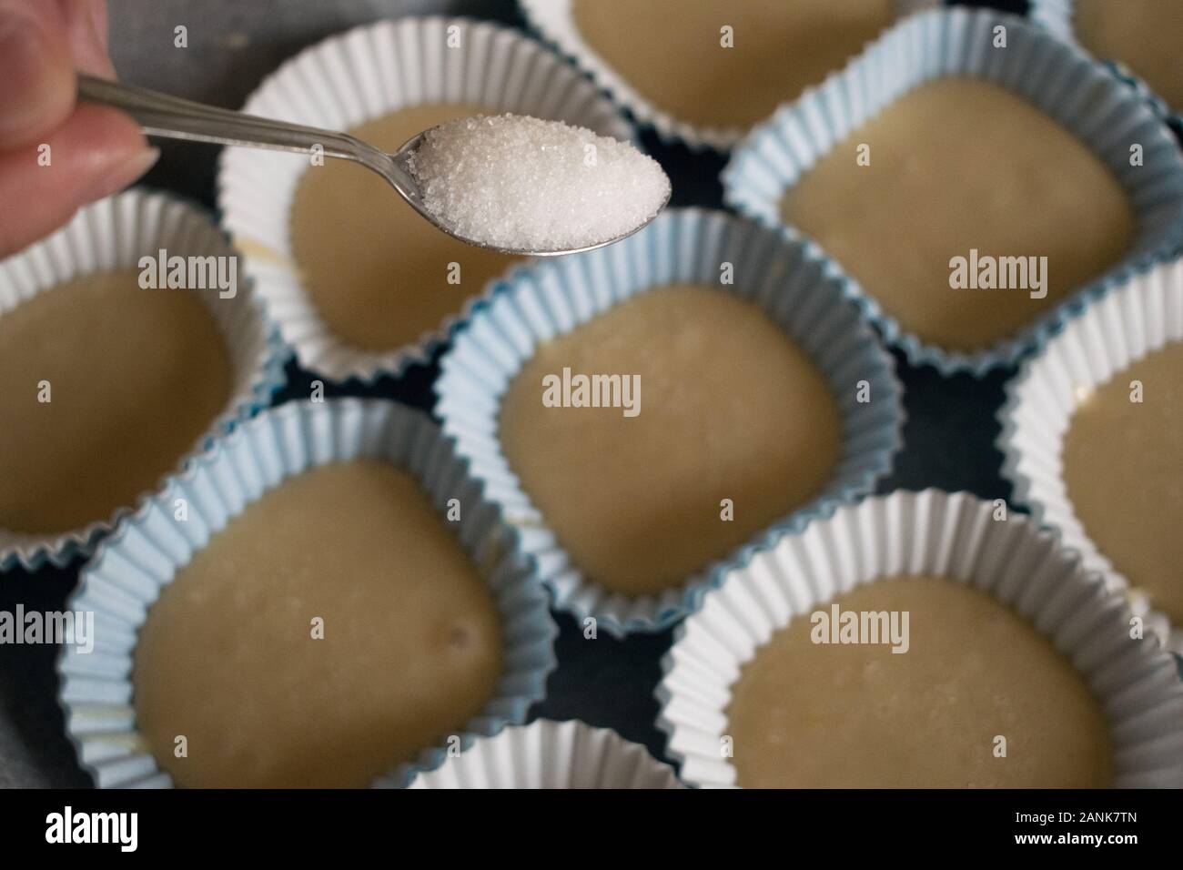 Blick auf einem Teelöffel mit Zucker in der hausgemachte Muffins zu setzen Stockfoto
