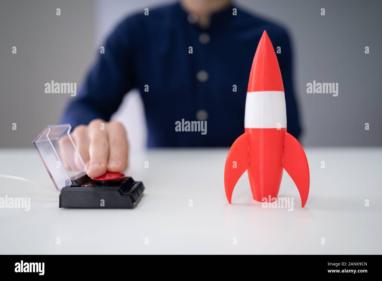 Der Geschäftsmann Hand mit Raketen durch Drücken der roten Taste Stockfoto