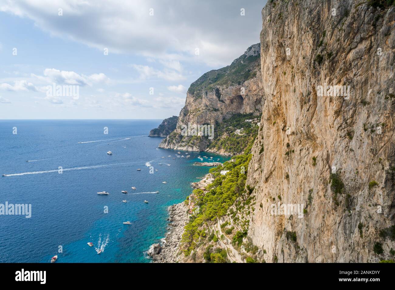 Felsen und Klippen der Insel Capri. Sicht auf das Meer der Bucht mit kleinen lokalen Boote und perfekte Kletterwände. Capri, Italien. Stockfoto
