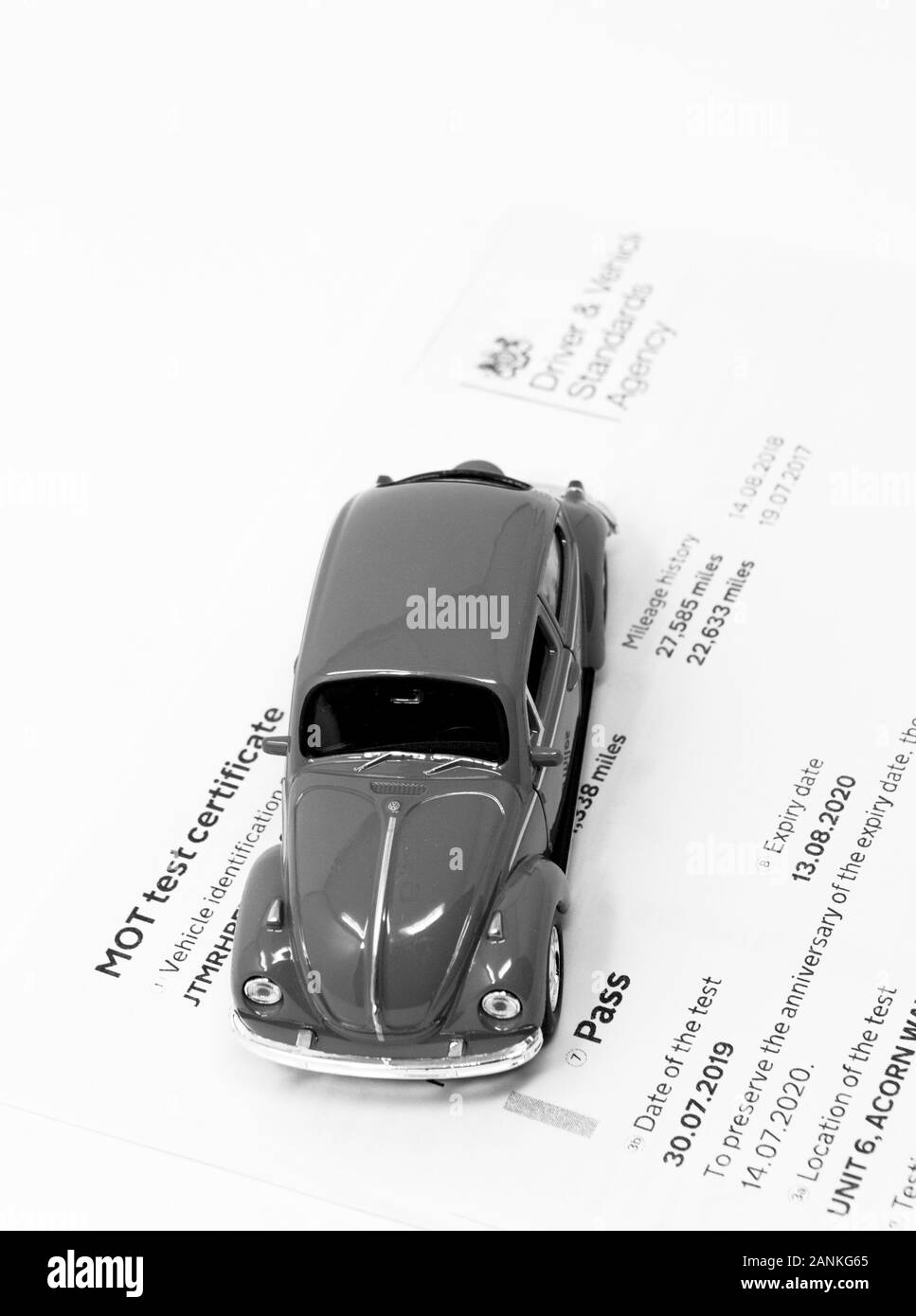 Rotes Volkswagen Beetle Spielzeug mit MOT-Prüfzertifikat. Stockfoto