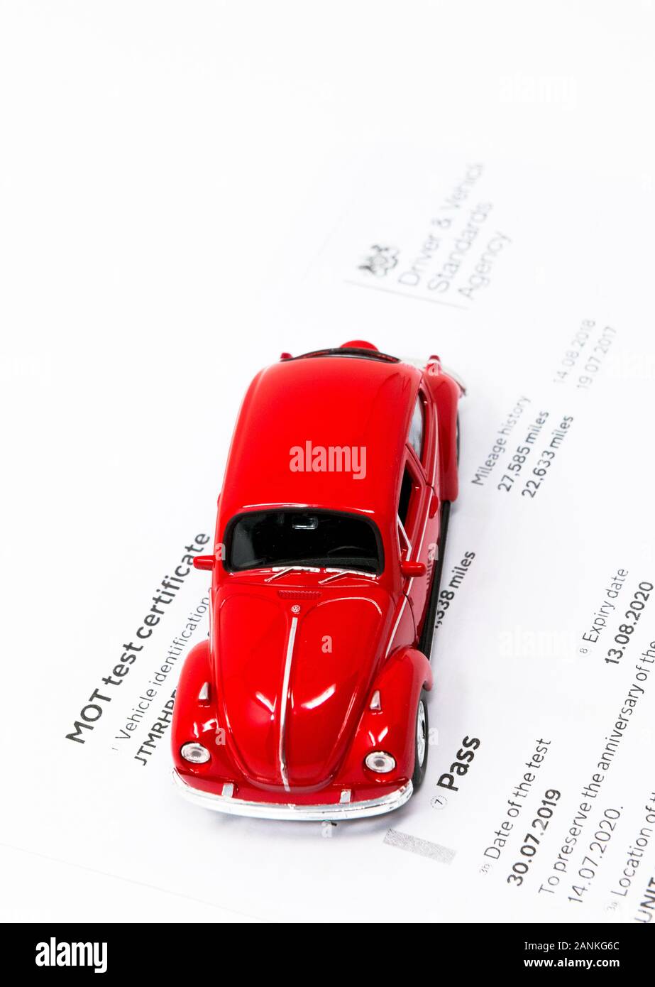 Rotes Volkswagen Beetle Spielzeug mit MOT-Prüfzertifikat. Stockfoto