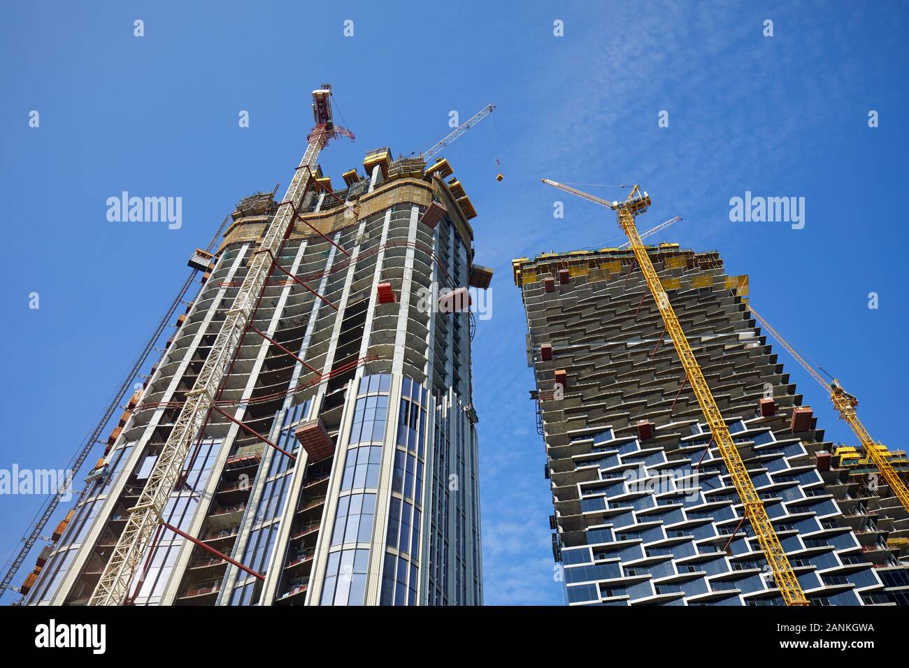 DUBAI, VEREINIGTE ARABISCHE EMIRATE - November 19, 2019: Wolkenkratzer im Bau mit Kränen, Low Angle View an einem sonnigen Tag, Clear blue sky in Dubai Stockfoto