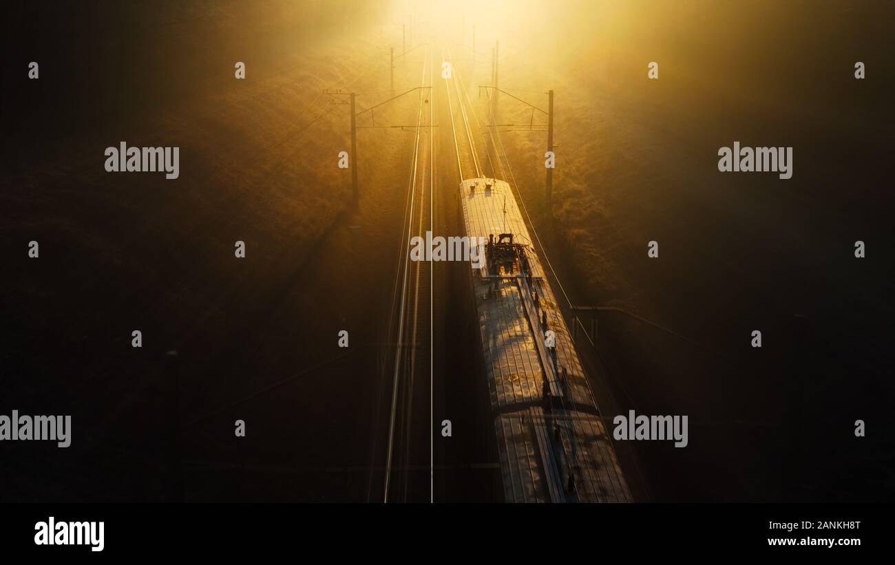 Der Zug fährt von der Dunkelheit in Richtung Sonnenuntergang, Bewegung, Licht, Konzept Stockfoto