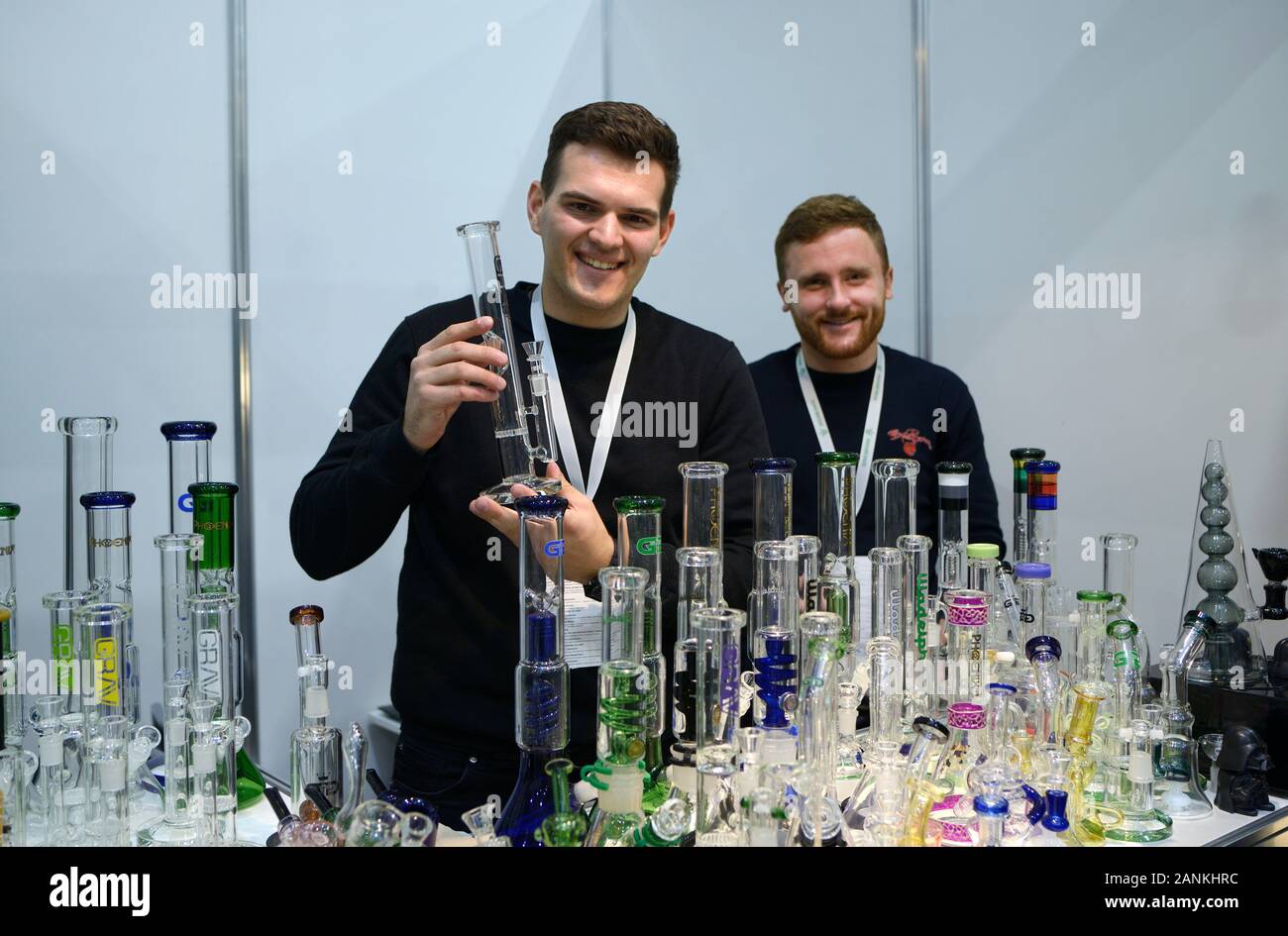 Verkäufer stehen an der Theke und Holding handgemachtes Glas Bong für das Rauchen von Marihuana, viele Bongs auf einem Tisch platziert. Oktober 11, 2019. Kiew, Ukraine Stockfoto