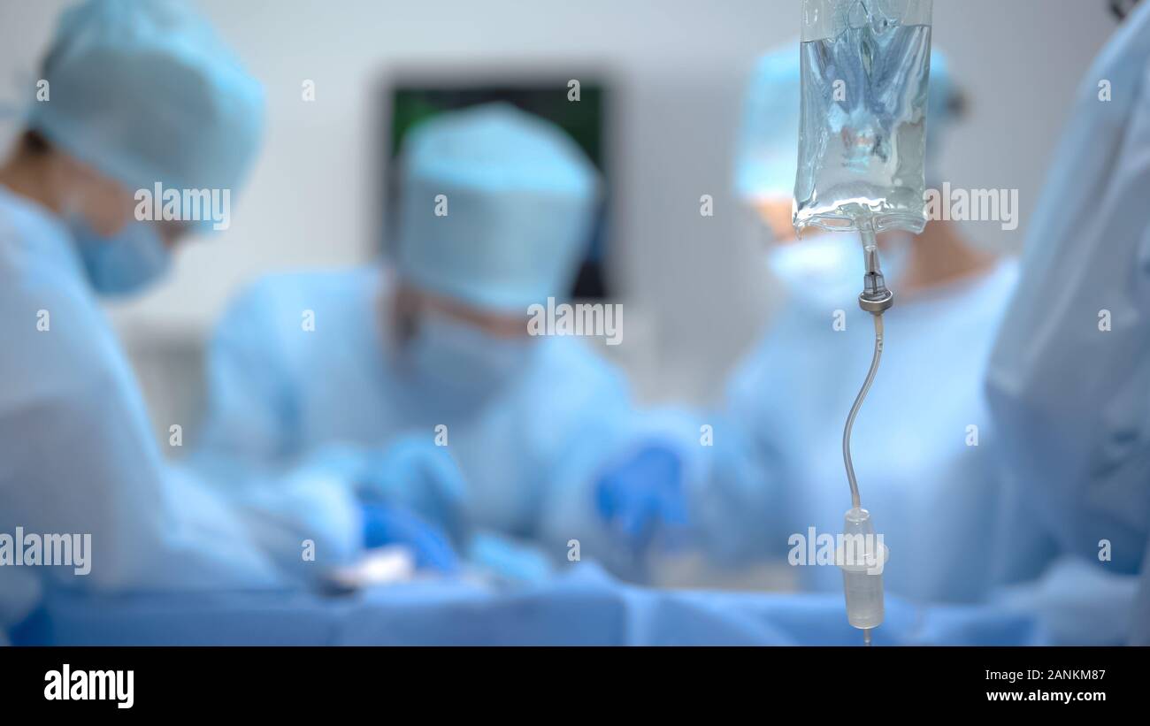 Medizinische Infusionsbeutels auf dem Hintergrund des Chirurgen Team in Betrieb Raum arbeiten Stockfoto