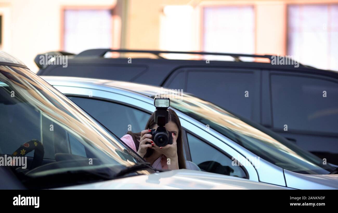 Weibliche Yellow Press Journalist verstecken am Parkplatz, Fotografieren, Sensation Stockfoto