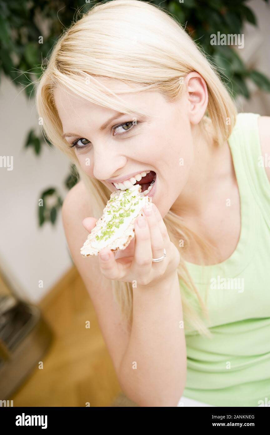 Junge Frau isst Knäckebrot - junge Frau isst Knäckebrot Stockfoto