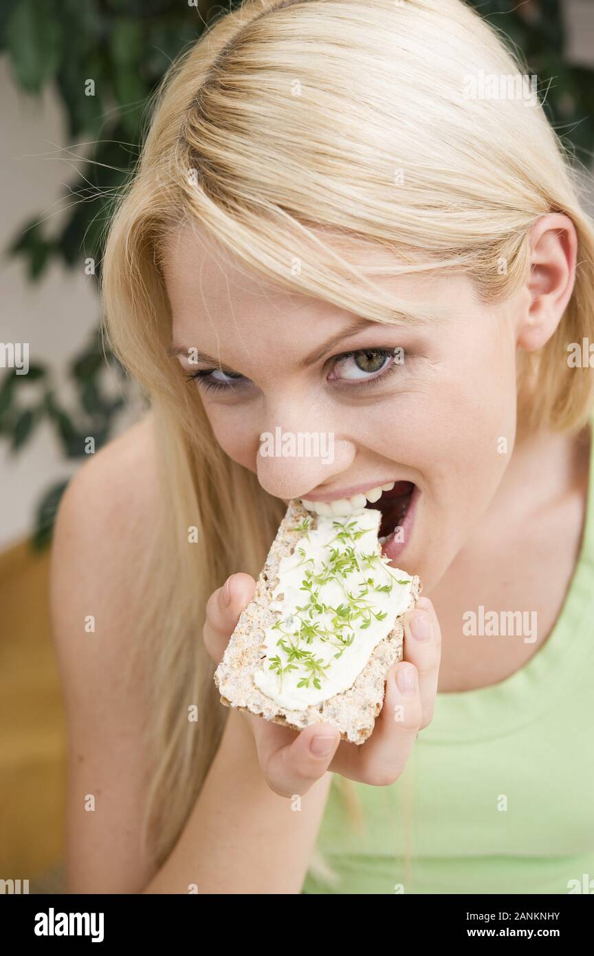 Junge Frau isst Knäckebrot - junge Frau isst Knäckebrot Stockfoto