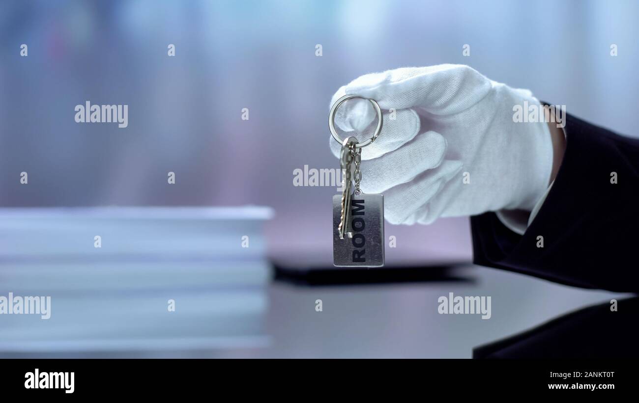 Hotel administrator Holding Schlüsselanhänger mit Wort Zimmer geschrieben, HoReCA Stockfoto