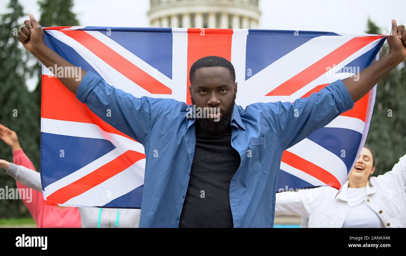 Böse schwarze Mann anheben Großbritannien Flagge, brexit Protest, Migration Krise Stockfoto