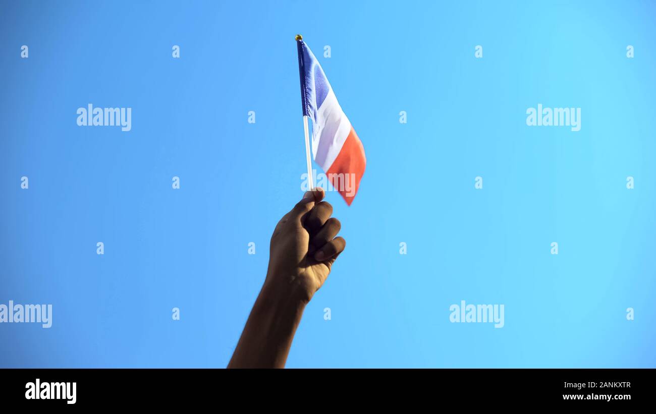 Person, die Flagge von Frankreich am Himmel Hintergrund, Patriotismus, Freiheit, close-up Stockfoto