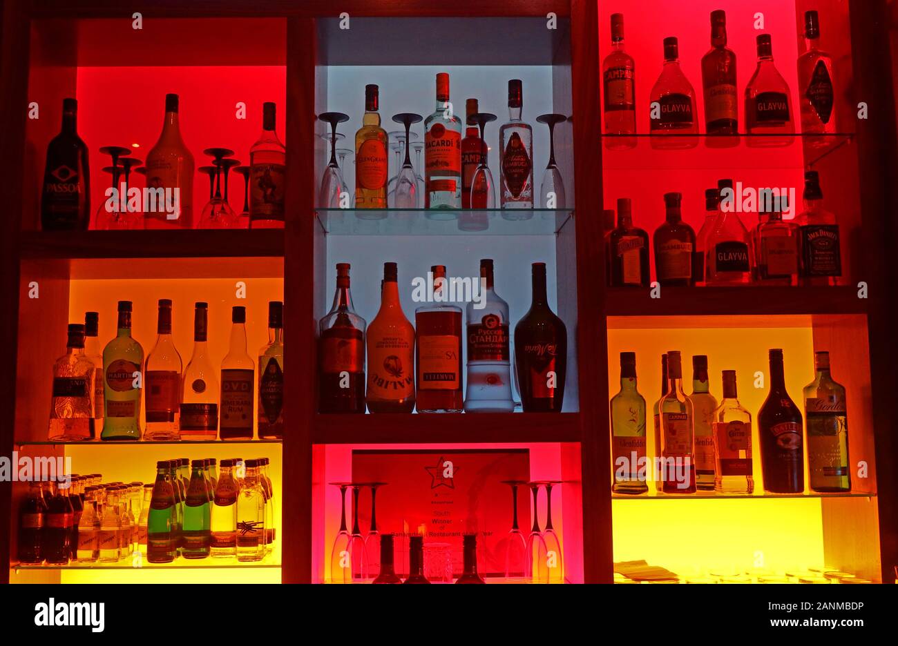 Alkohol Spirituosen für Cocktails auf eine bunt beleuchtete Bar, Gin, Whisky, Wodka, Weinbrand, Liköre und Bitter/Mixer Stockfoto