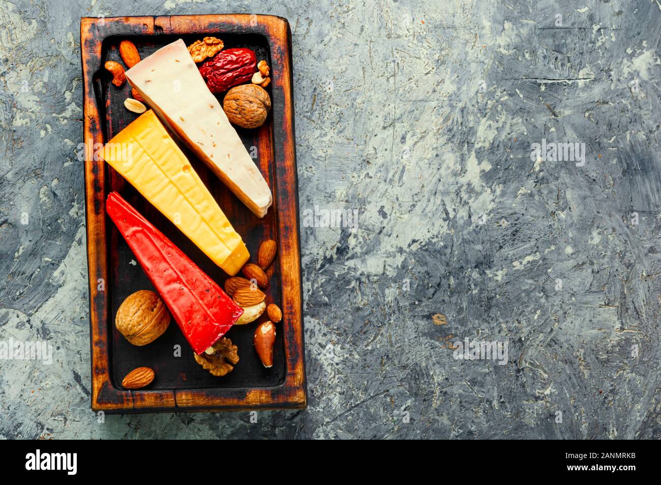 Küche mit verschiedenen Arten von köstlichen Käse auf dem Tisch. Drei Scheiben Käse auf einem hölzernen Küche board Stockfoto