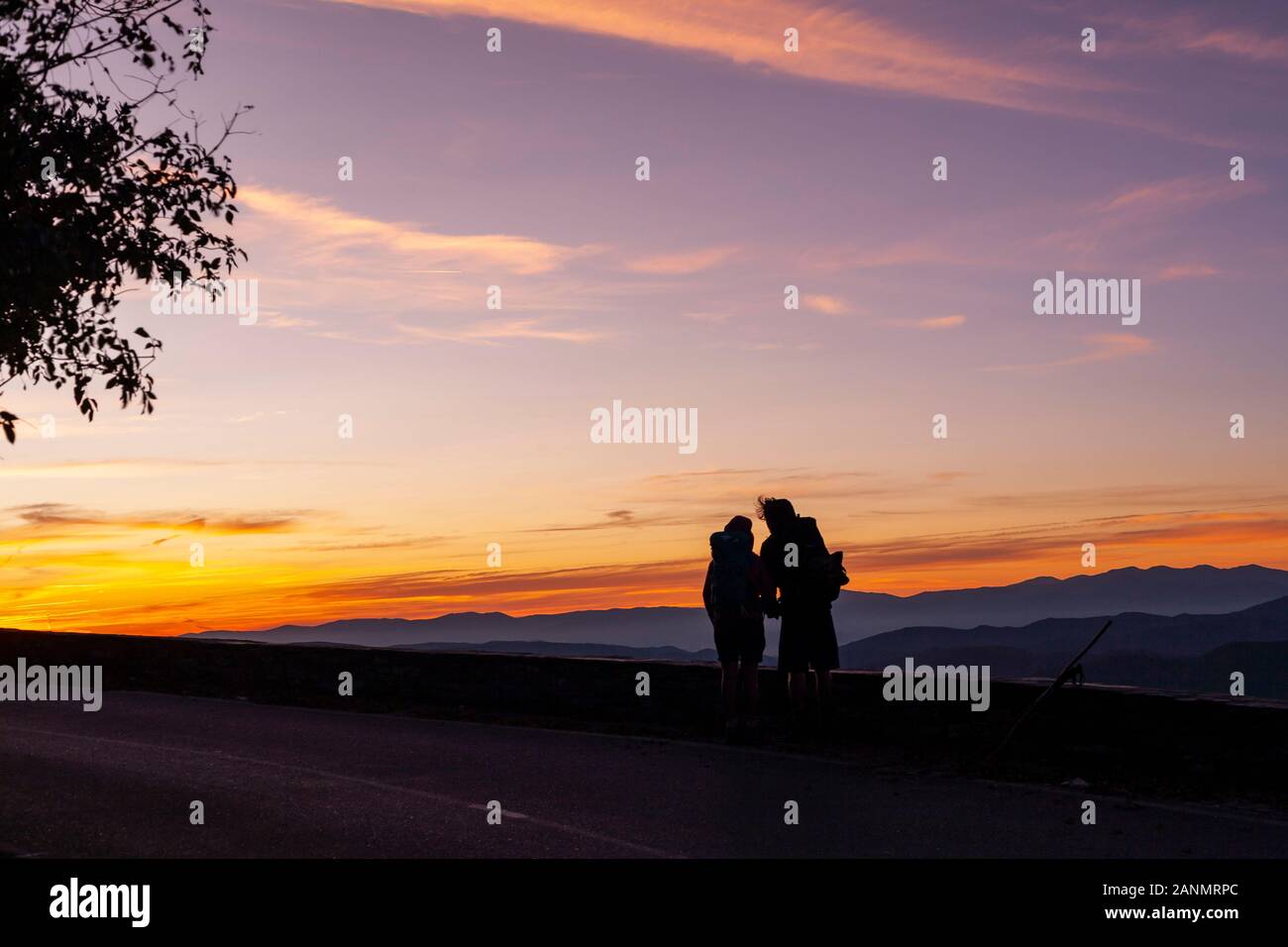 Ein Paar beobachtet den Sonnenaufgang. Geschichte und Drama spielen sich in O Cebreiro Spanien mit dramatischen galicischen Landschaften ab. El Camino de Santiago, Spanien. Stockfoto
