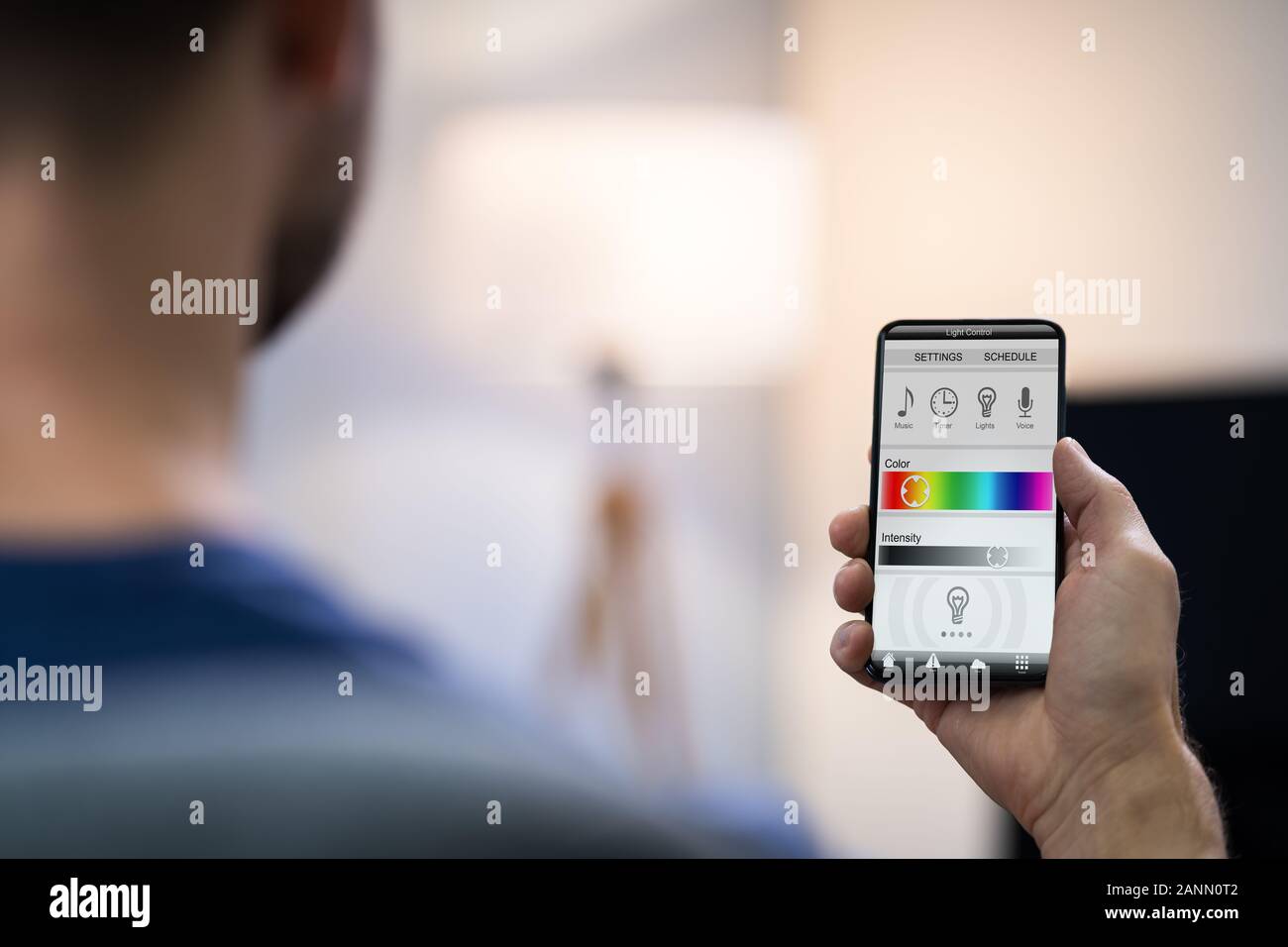 Nahaufnahme einer menschlichen Hand Einstellen elektrisches Licht durch Handy zu Hause Stockfoto