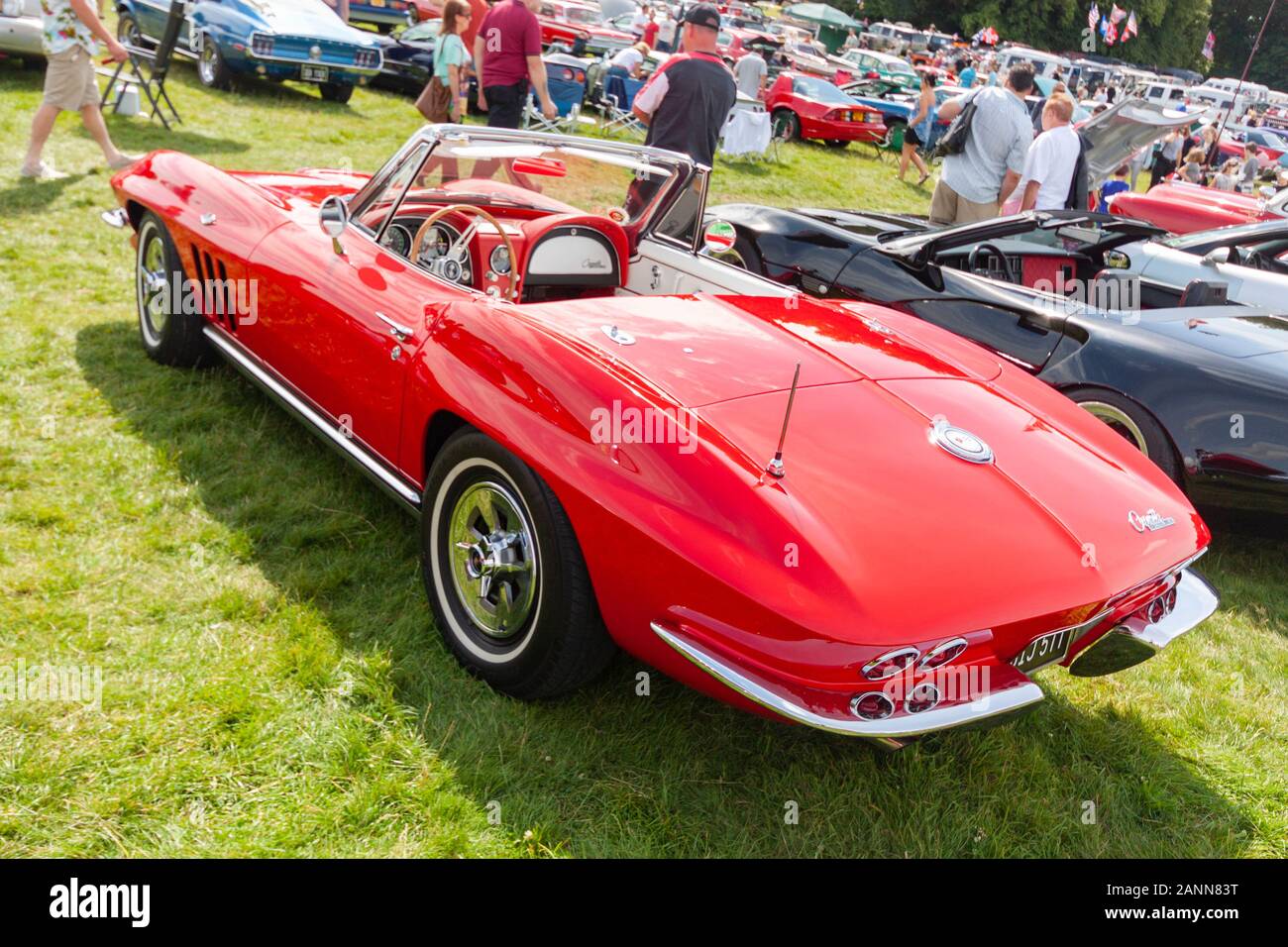 Rotes Oldtimer-Cabrio Chevrolet Corvette auf der Oldtimer-Show mit Menschenmenge und anderen Oldtimern im Hintergrund Stockfoto