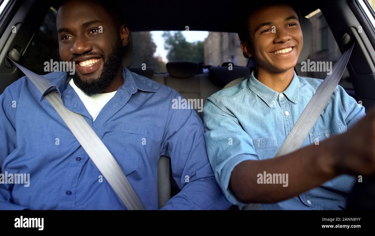 Happy afro-amerikanischen Vaters und jugendlich im Auto sitzen, Vater mit Söhnen gerne Laufwerk Stockfoto