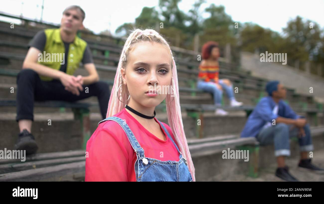 Ernsthafte weibliche Tausendjährigen suchen Kamera sitzen College Stadion, neue Generation Stockfoto