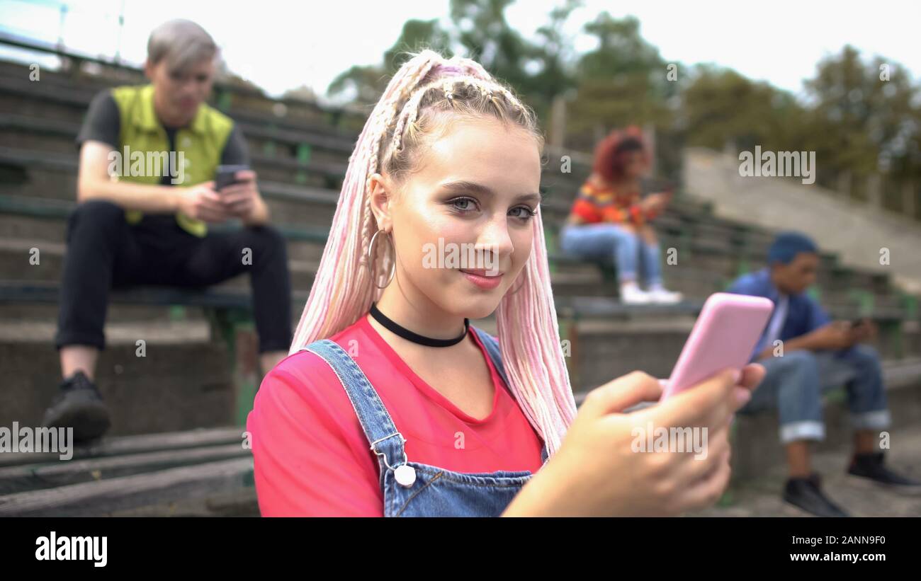 Lächelnd weibliche tausendjährigen Scrollen smartphone Fotos, digitale Generation, App Stockfoto