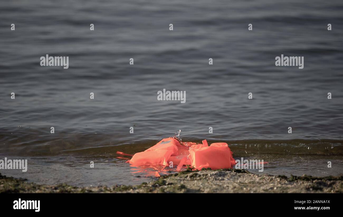 Schwimmweste schwimmen auf Wasser nahe der Küste, Suche nach Opfern nach der Katastrophe Stockfoto