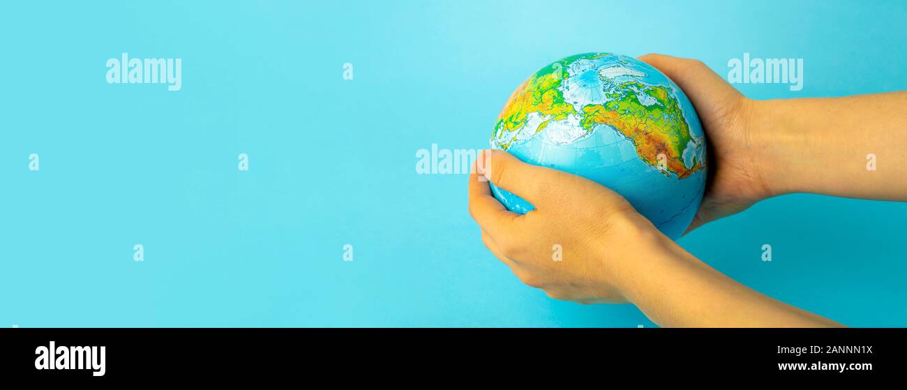 Erhaltung und Schutz der Natur und der Erde. Globus in weibliche Hände auf blauem Hintergrund. Ökologie und Naturschutz Konzept. Stockfoto