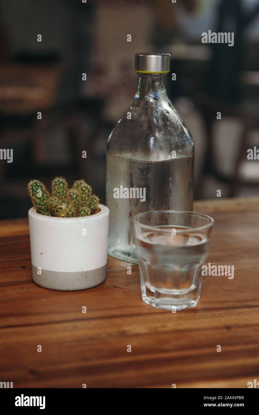 Trinkwasser. Glas Wasser mit einer Flasche am Tisch Stockfoto