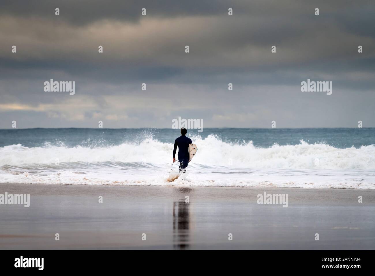 Ein Surfer in das Meer am Strand von Carcavelos in Oeiras, Portugal Stockfoto
