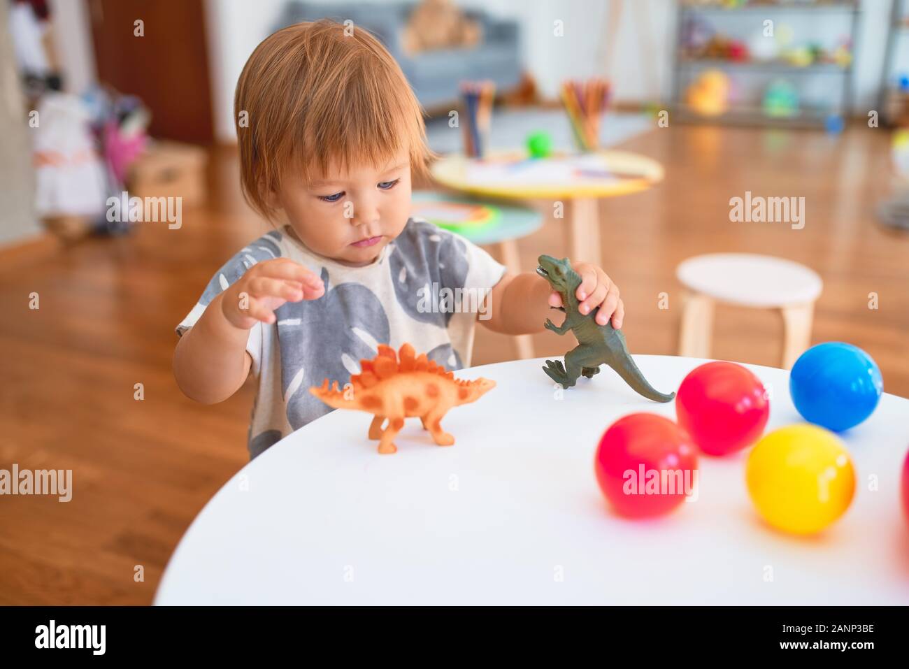 Adorable Kleinkind spielen mit Dinosauriern um viele Spielsachen im  Kindergarten Stockfotografie - Alamy