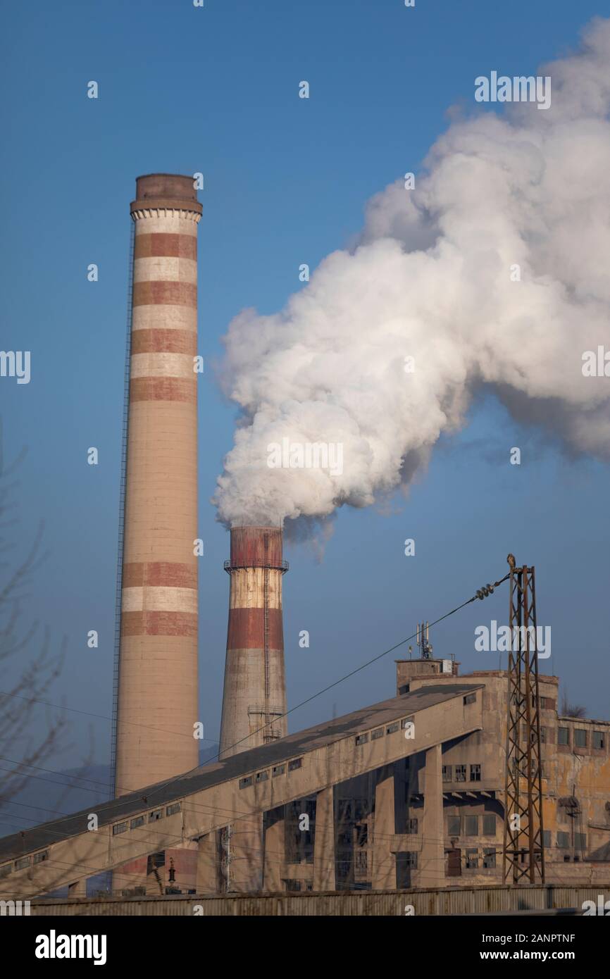 Schornstein Rauchen und elektrische Pole, Stadt thermisches Kraftwerk Hintergrund blau. Rohre, Gefahr. Stockfoto