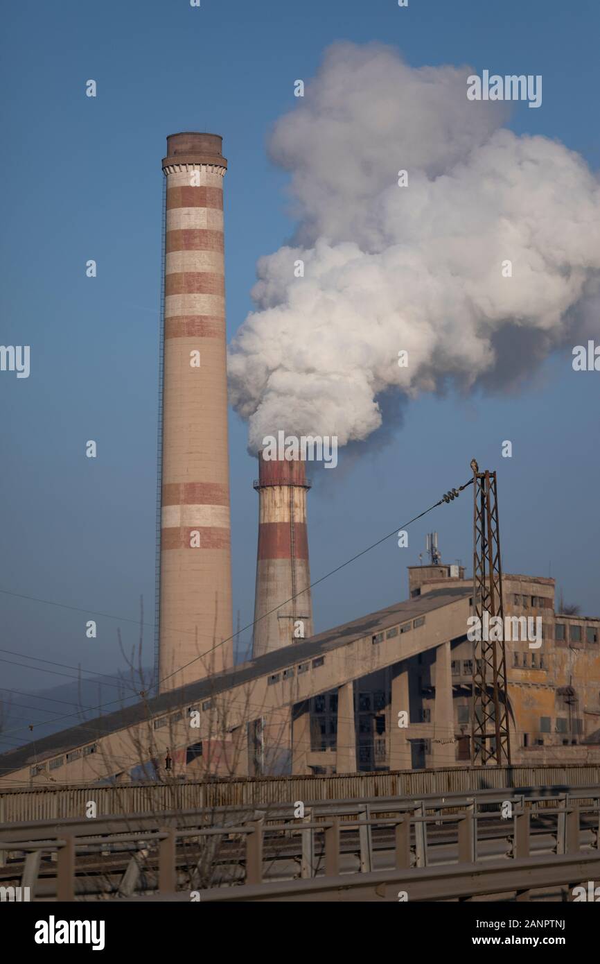 Schornstein Rauchen und elektrische Pole, Stadt thermisches Kraftwerk Hintergrund blau. Rohre, Gefahr. Stockfoto