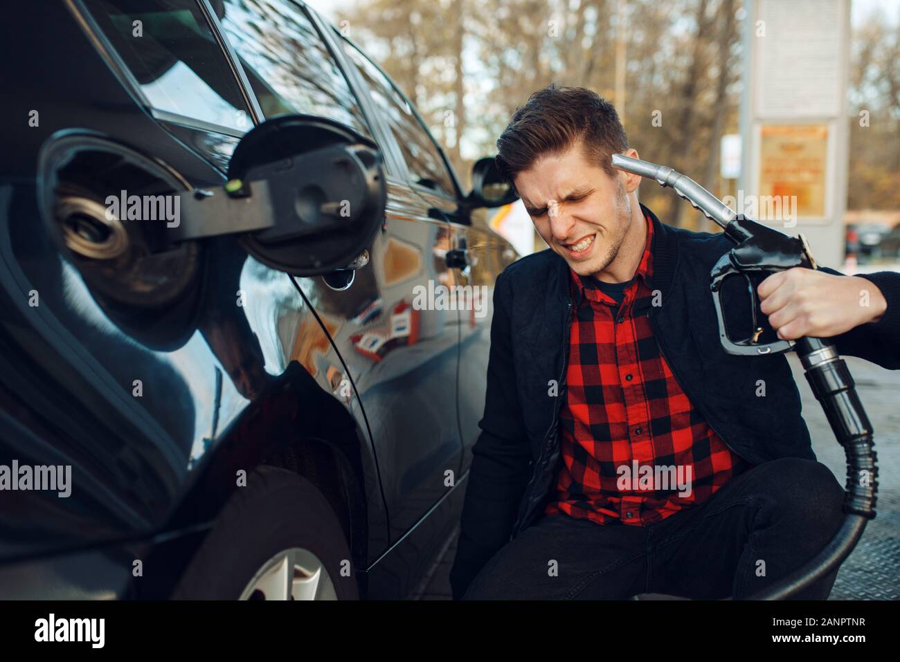 Mann mit Waffe auf seinen Kopf auf Gas Station Stockfoto