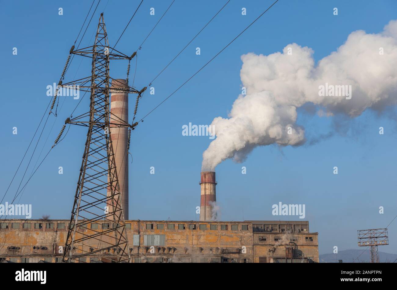 Schornstein Rauchen und elektrische Pole, Stadt thermisches Kraftwerk Hintergrund blau. Rohre, Gefahr. Stockfoto