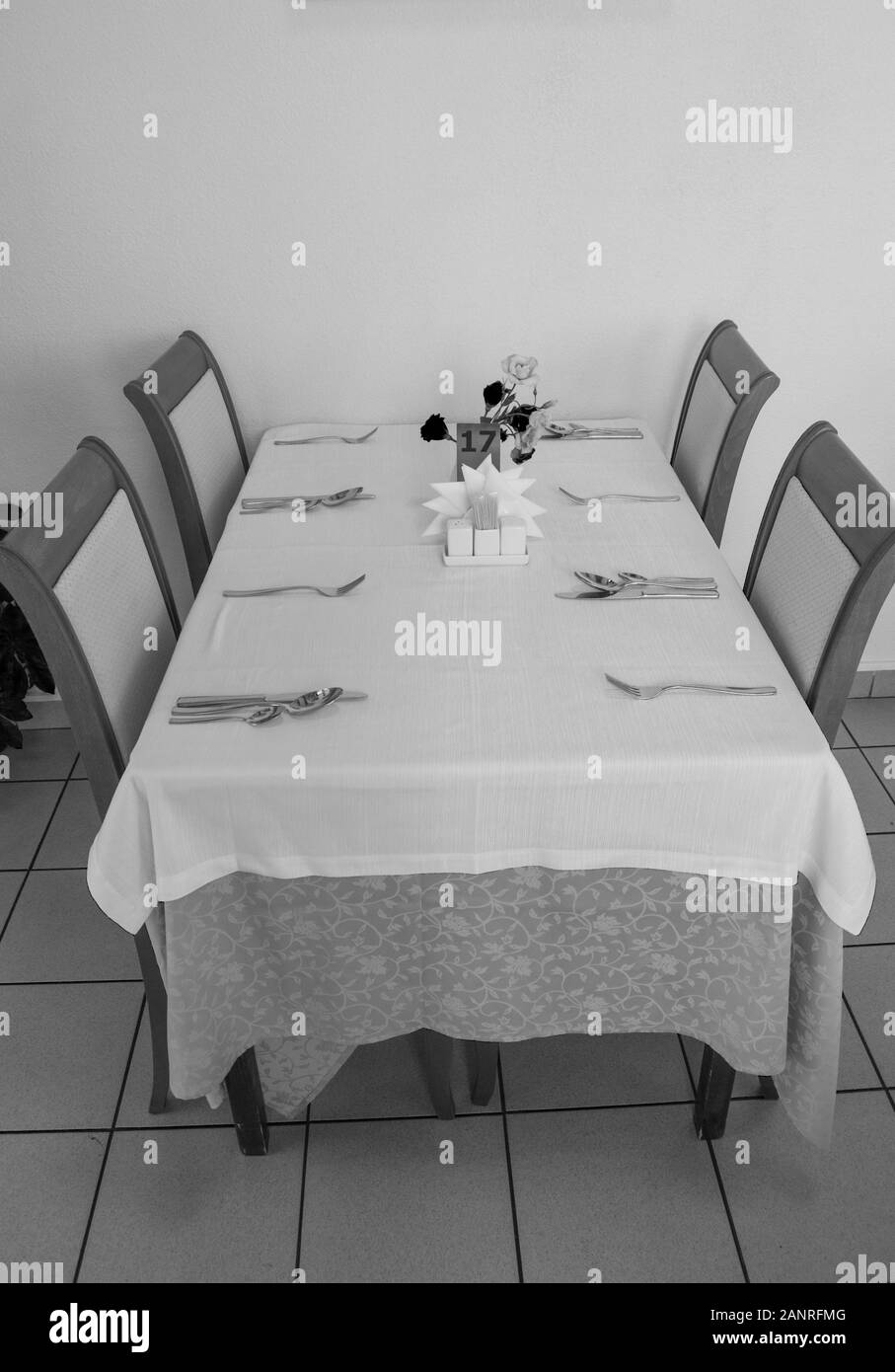 Festliche Tisch mit Tischdecke und Besteck im Restaurant warten auf Gäste, vertikaler, Seitenansicht, schwarzen und weißen Rahmen Stockfoto