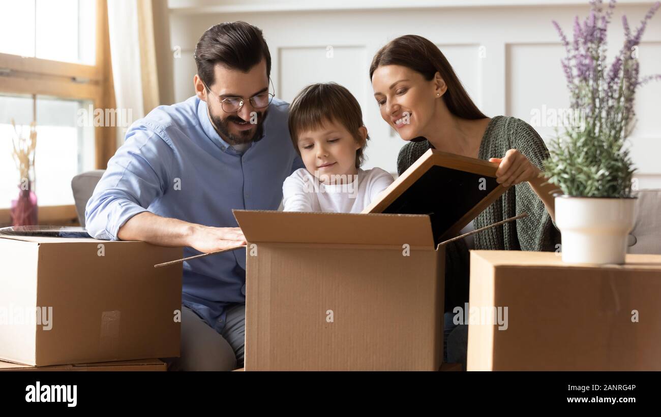 Glückliche Familie Auspacken von Kisten mit kleinen Sohn Stockfoto