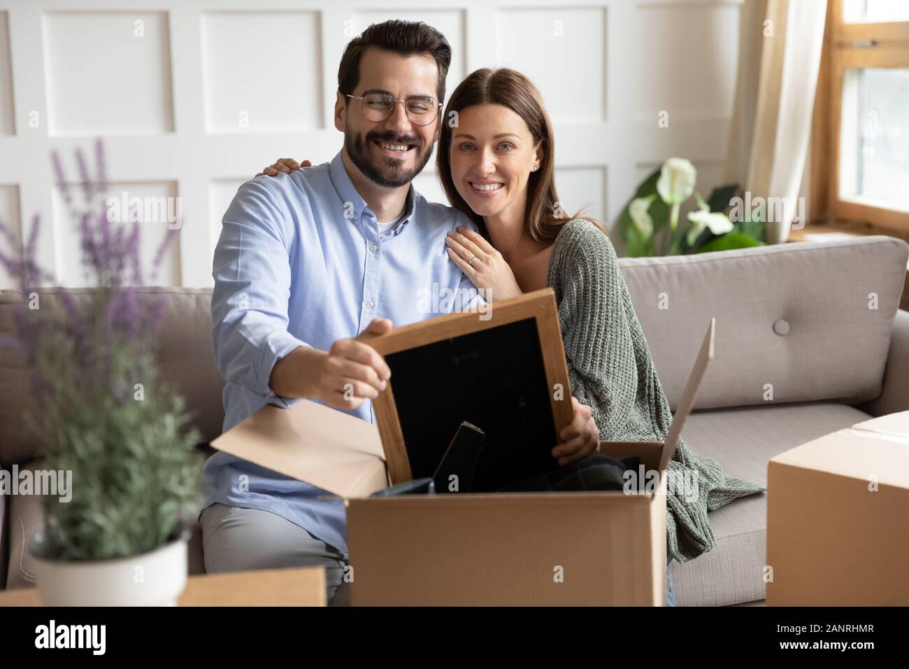 Lächelndes Paar Kisten auspacken Beilegung im neuen Zuhause Stockfoto