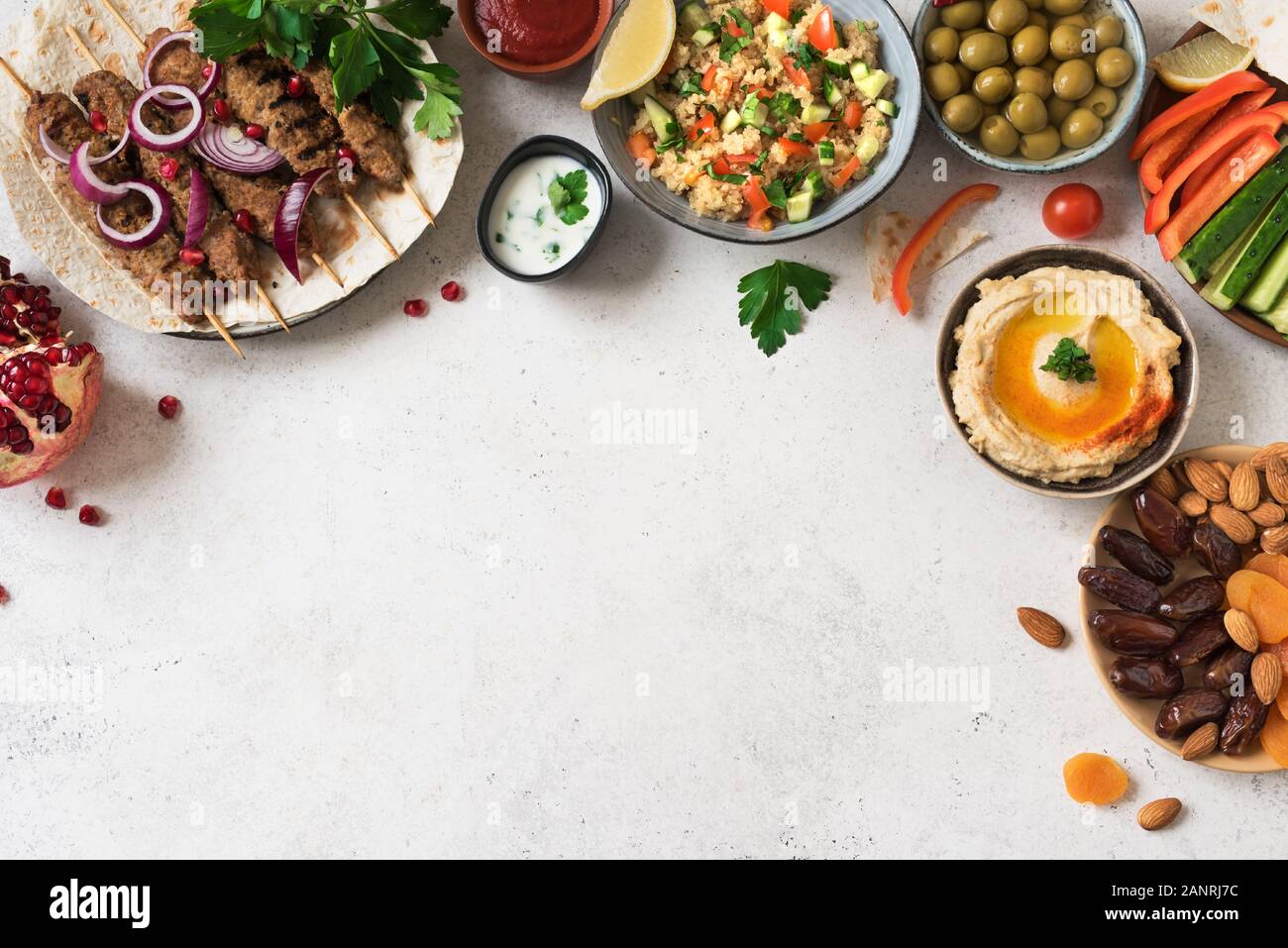 Arabische und Orientalische Küche, Tisch. Fleisch Kebab, Hummus, tabbouleh Salat, Saucen, Oliven, Pita, Termine Früchte, Nüsse, Granatapfel. Stockfoto
