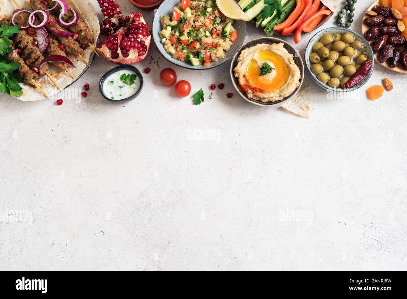 Arabische und Orientalische Küche, Tisch. Fleisch Kebab, Hummus, tabbouleh Salat, Saucen, Oliven, Pita, Termine Früchte, Nüsse, Granatapfel. Stockfoto