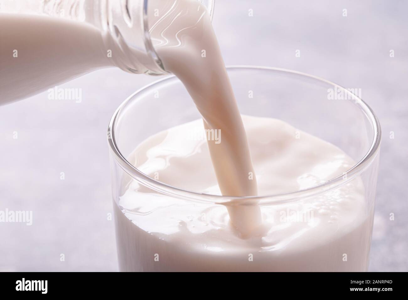 Milch in ein Glas gießen Stockfoto