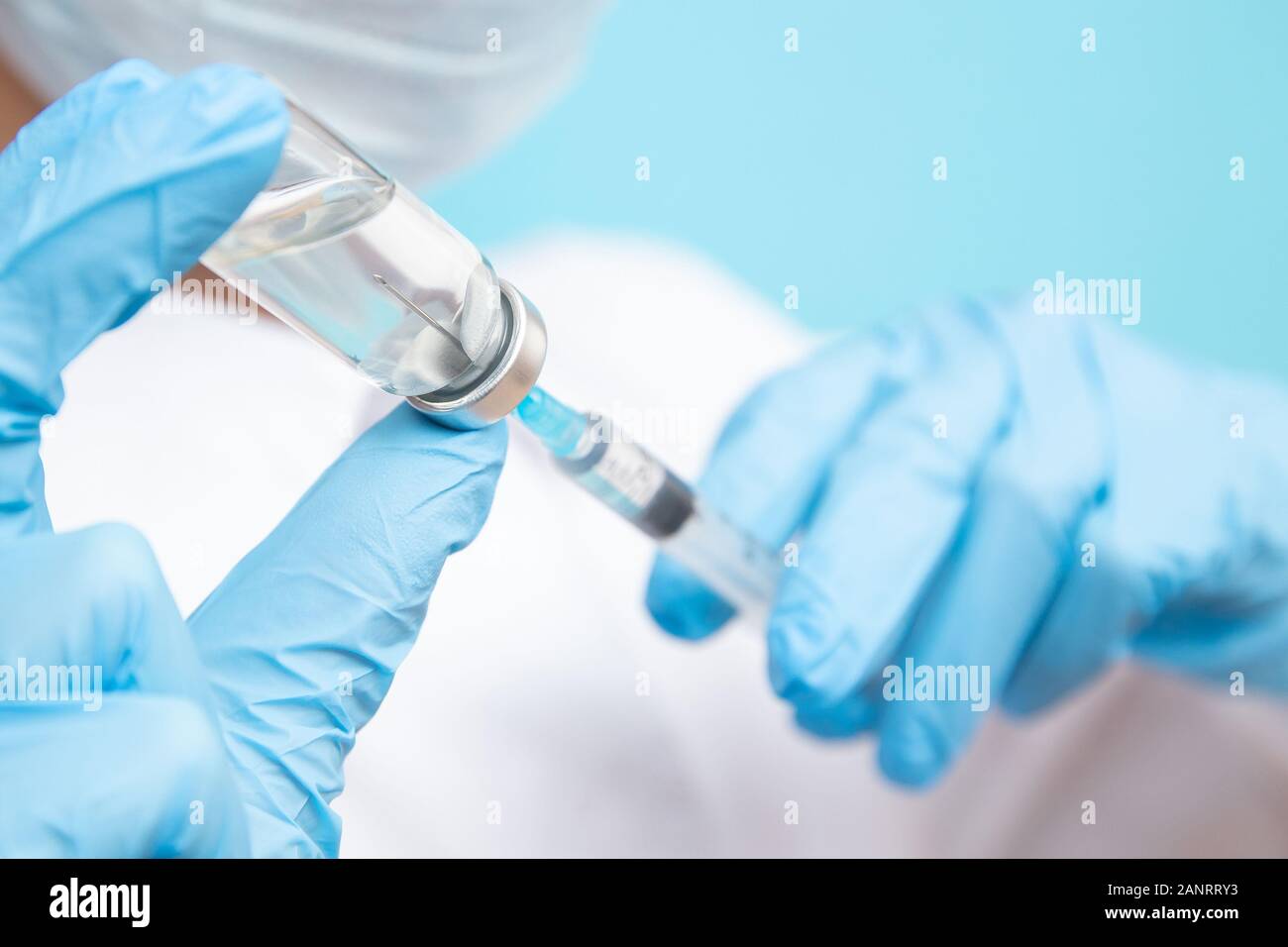 Arzt Hand halten Sie die Spritze und den Impfstoff in blaue Handschuhe weißes Fell. Krankheit Injektion Konzept Stockfoto