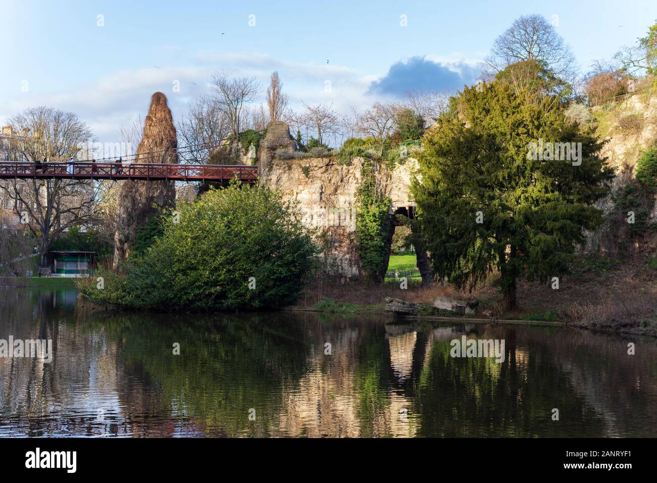 Der Parc des Buttes-Chaumont, die rote Brücke und der See im Winter 2020, Fünfter - größten öffentlichen Park in Paris, Frankreich. Stockfoto