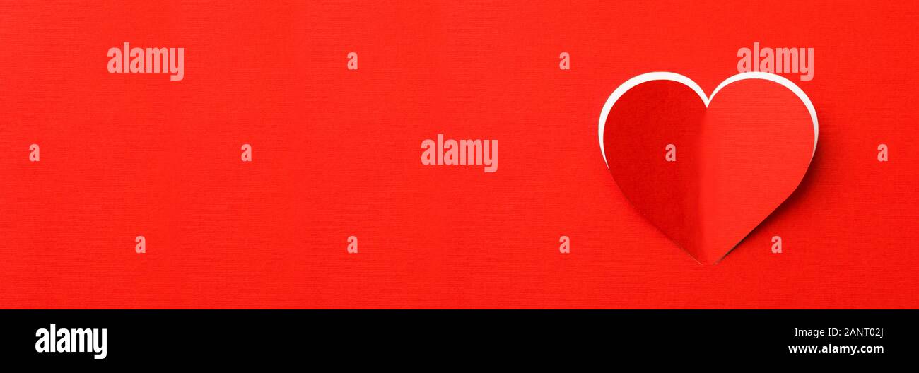 Valentines Tag Hintergrund. Ein rotes Blatt Papier mit ein ausgeschnittenes Herz. Weißer Hintergrund. Stockfoto
