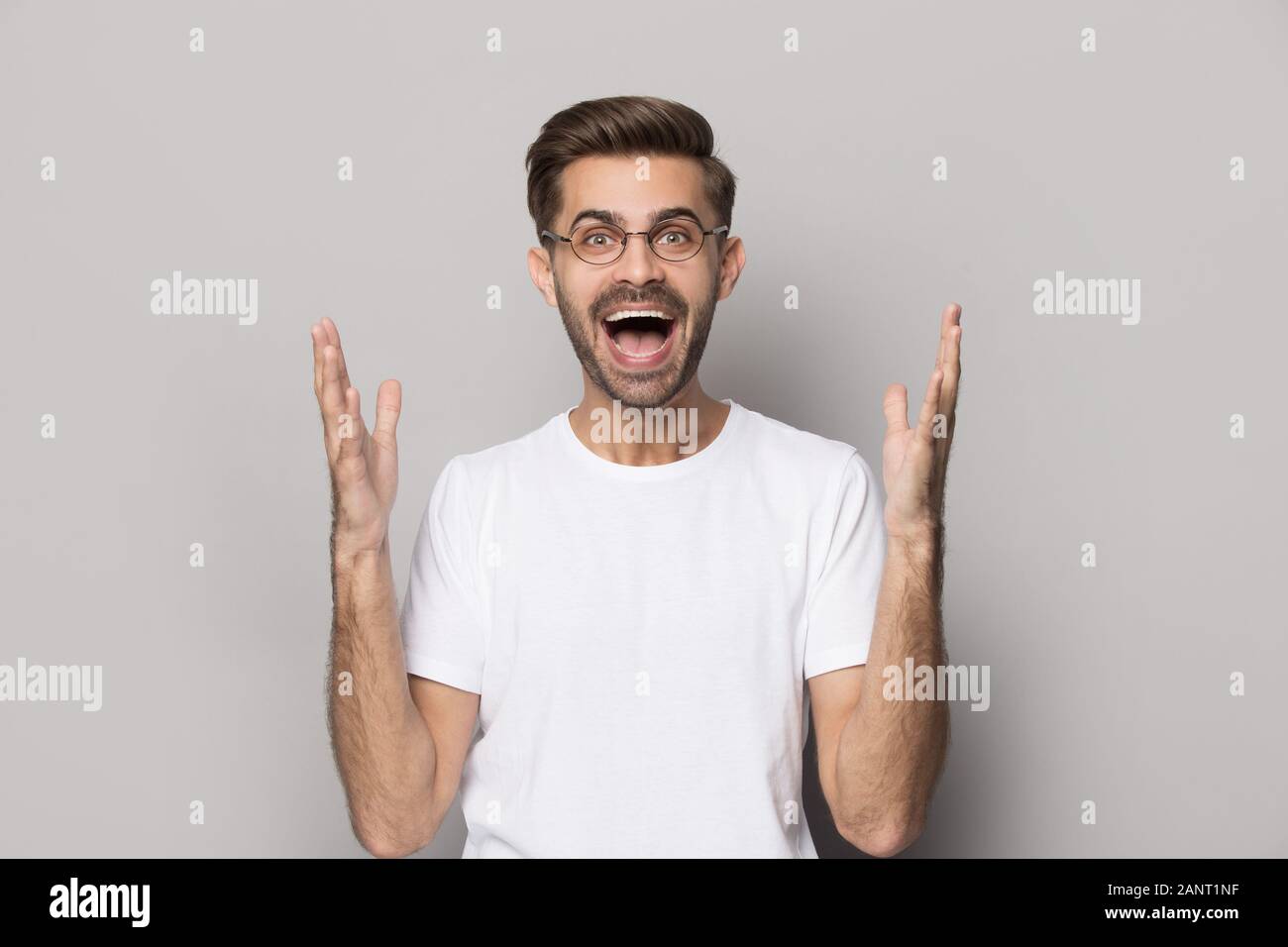 Fröhlicher junger Mann in Brillen Anhörung unglaublich gute Nachrichten. Stockfoto