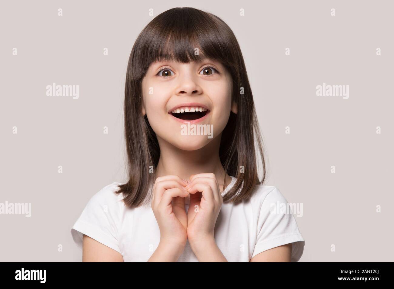 Fröhlich aufgeregten kleinen Mädchen zeigen Herz Liebe Geste. Stockfoto
