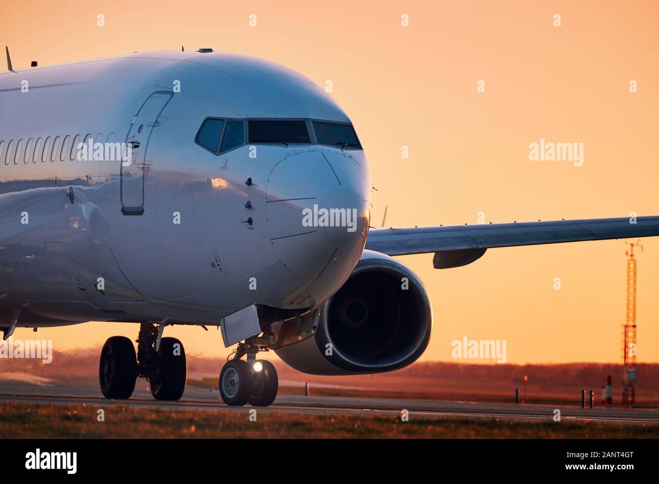 Verkehr am Flughafen. Commercial Airplane auf Start- und Landebahn am Golden Sunset. Stockfoto