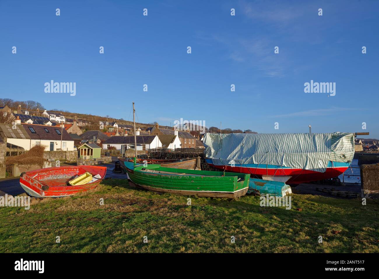 Kleine hölzerne Fischerboote gelagert werden, bis sie am Kai und auf dem Dorfplatz für den Winter in der Fischerei der Gemeinschaft der Johnshaven, Stockfoto