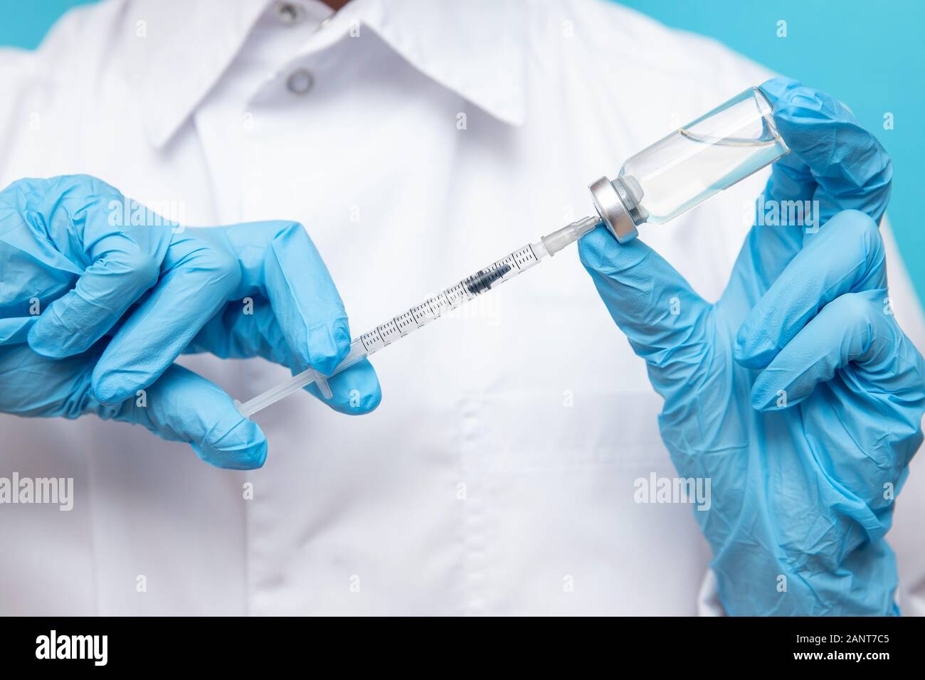 Arzt Hand halten Sie die Spritze und den Impfstoff in blaue Handschuhe weißes Fell. Krankheit Injektion Konzept Stockfoto