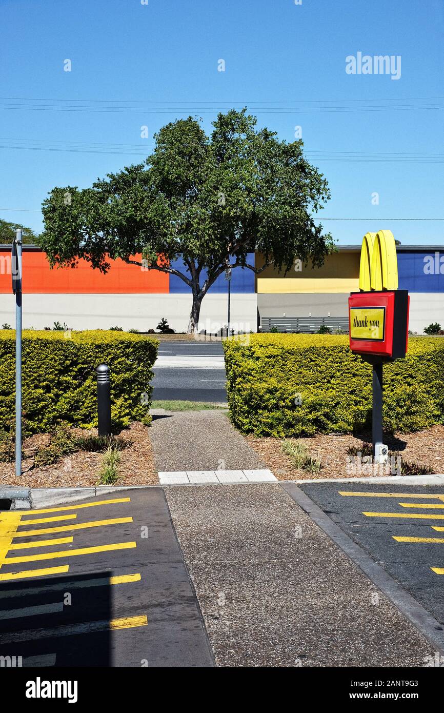 Eine "neue Topografik-Szene", die über einen fast Food Parkplatz, Linien, blockierte Farben und Geometrie und ein gelbes M einen blauen Himmel kontrastiert Stockfoto